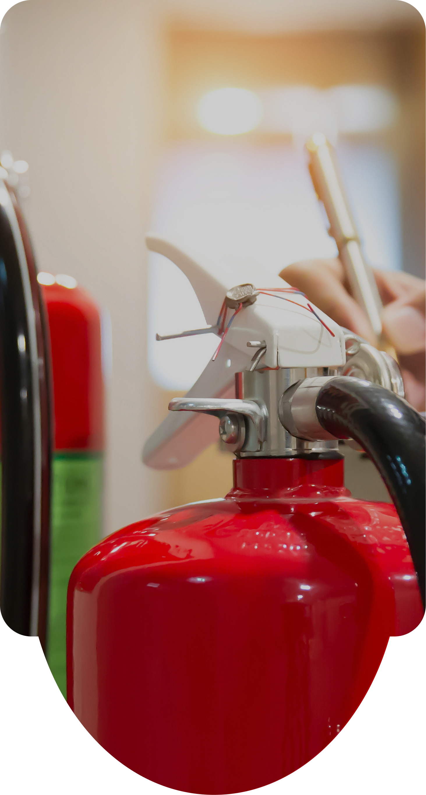 2つの赤い消火器が写っており、背景にはクリップボードとペンを持って点検を行っている人物の写真